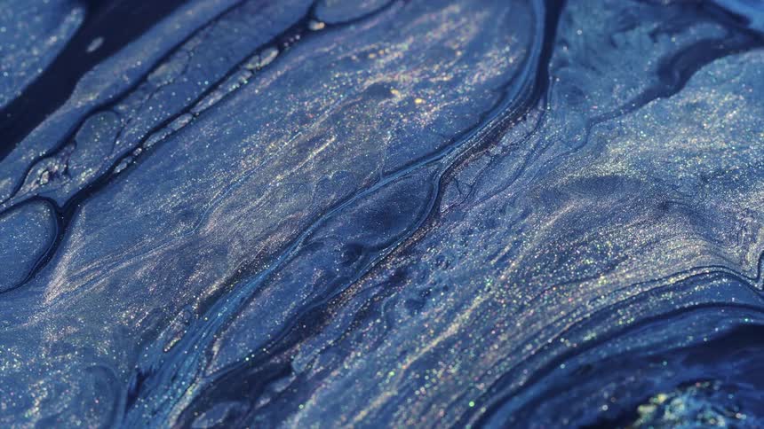 A close up of liquids mixing with streams of fluids and organic cell structures
