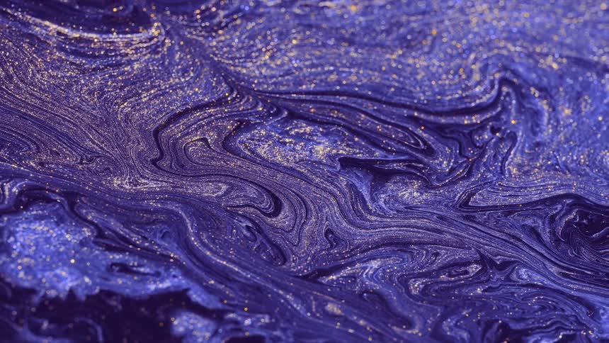 Purple and blue swirls dotted with golden glitter flow and swirl