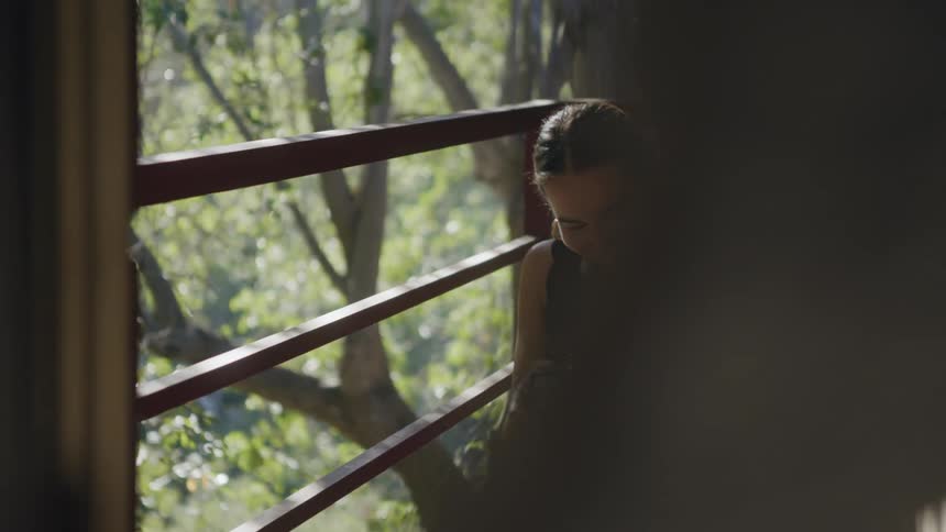 Young woman taking pictures with a camera outside the house in the forest