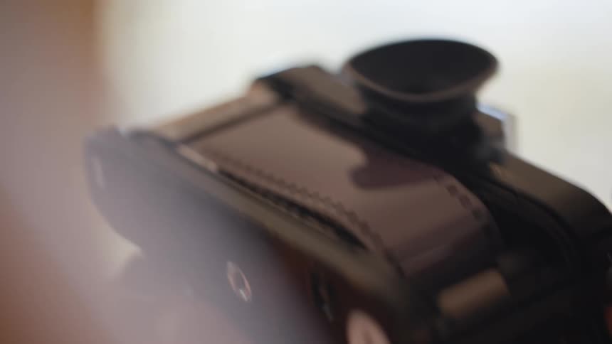 A woman loading film into a camera