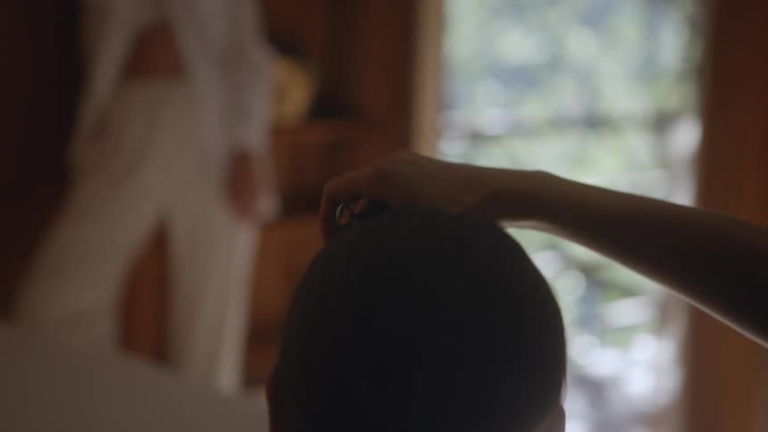 A woman in a room with a camera taking a picture of another woman with a wall and window in the background