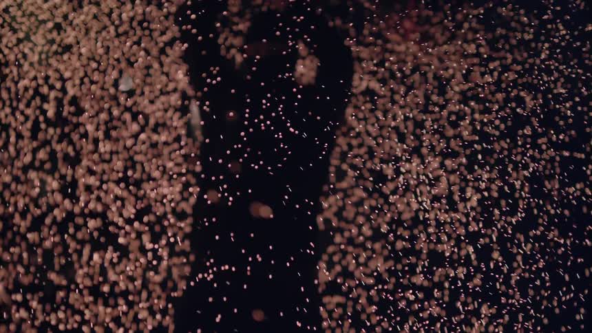 A person is spinning and shooting sparks from a stick