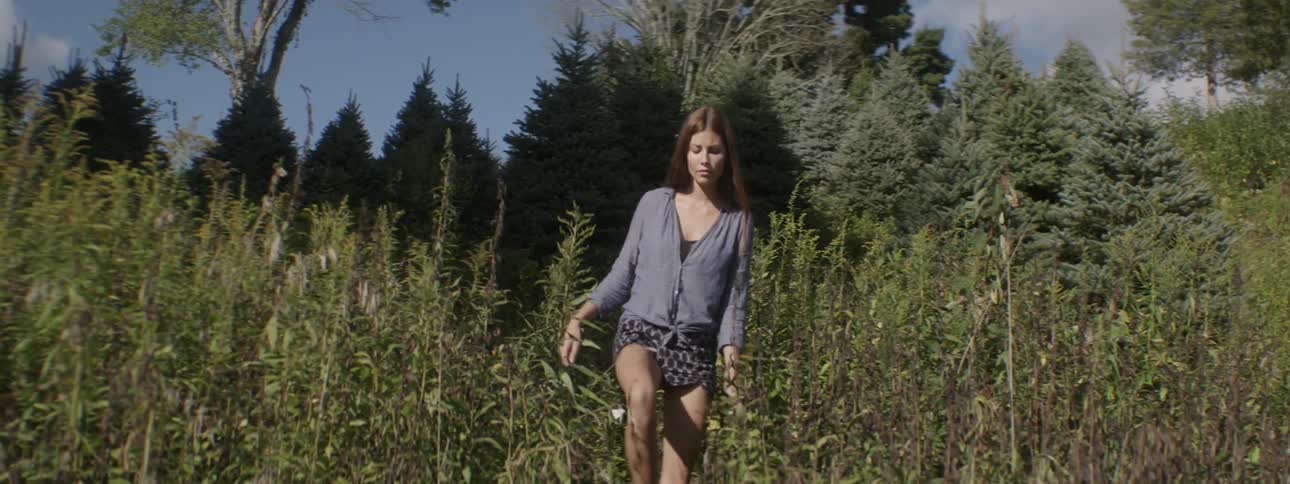 A woman is walking in the grass