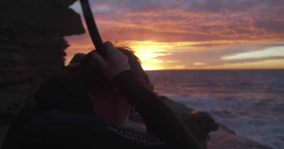 A man puts on his snorkel by the shore