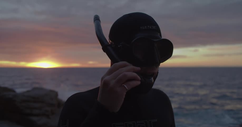 A man putting on a snorkel outdoors