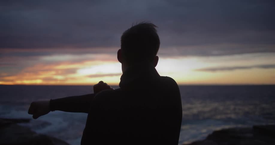 A man is stretching by the water
