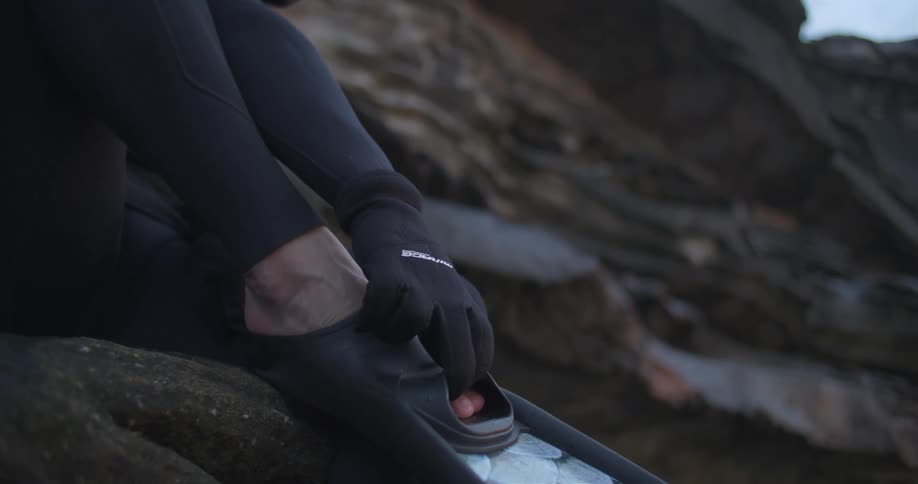 A person putting on flippers to go swimming