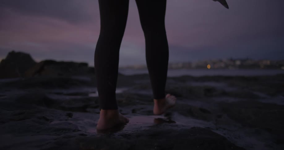 A person walks across a rough terrain near the waterfront