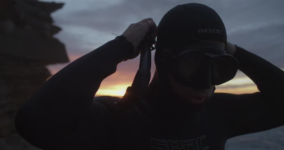 A man is putting on his snorkeling gear