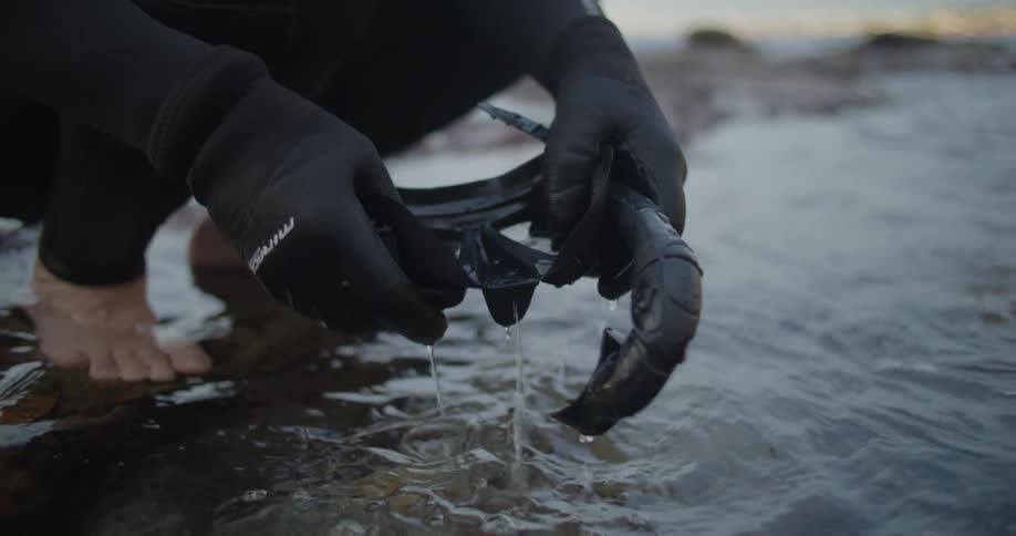 A view of someone rinsing off a snorkel and goggles