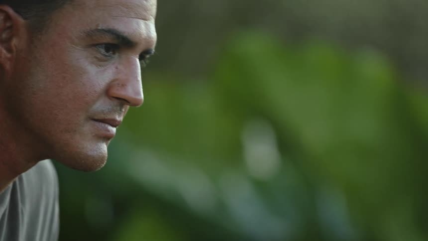 A man casts his glance downwards before looking upwards in a pensive manner