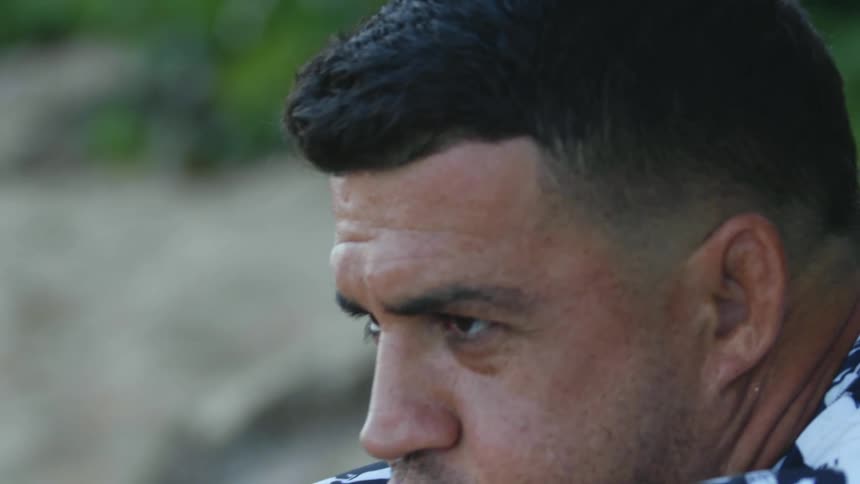 A man that is sitting outdoors on the beach