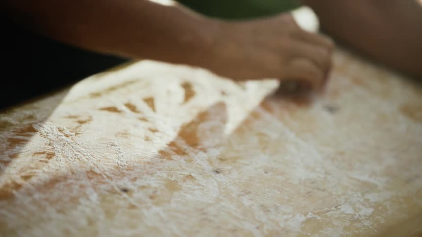 Man in Hawaii waxes wooden surfboard