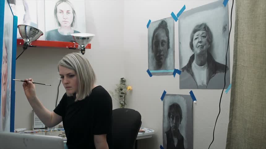 A woman is painting a portrait
