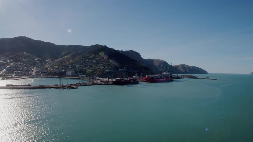 A town is revealed along a waterfront full of docks and ships