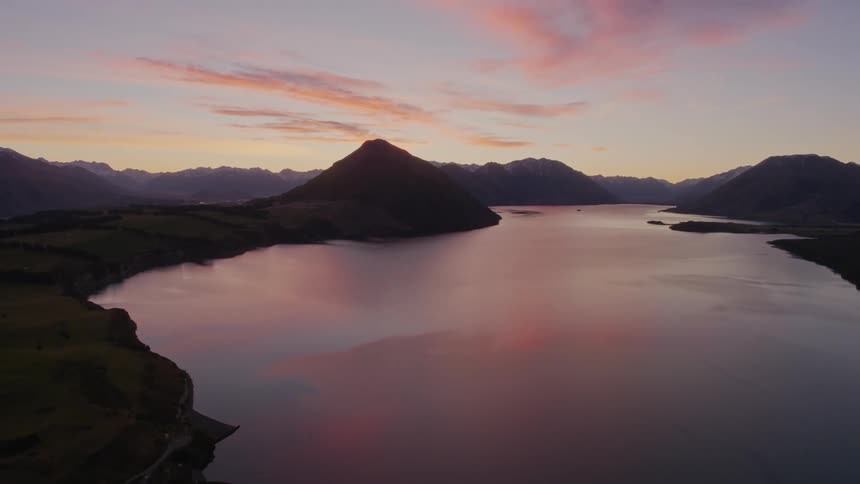 A river running through a mountainous countryside at sunset