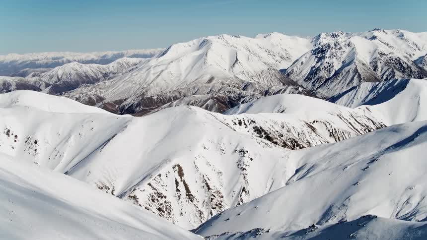 An aerial view of a mountain range covered in snow