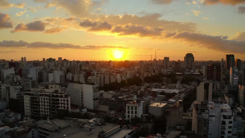 Sunrise shines brightly on a citys tall buildings and towers