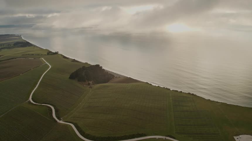 A landscape near the coast with the ocean sky and clouds in the background
