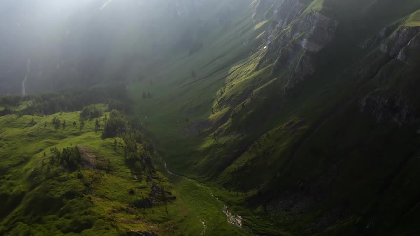Creek flows through the valley between mountains and a hill