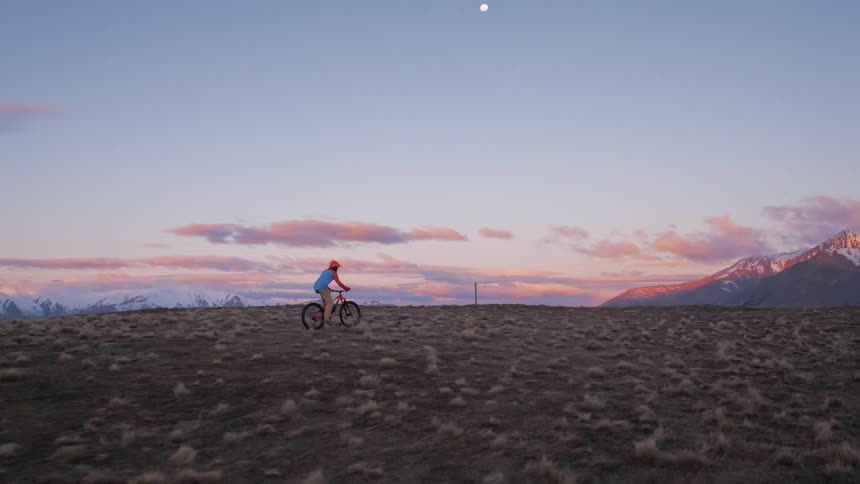 A man is riding his mountain bike over the field