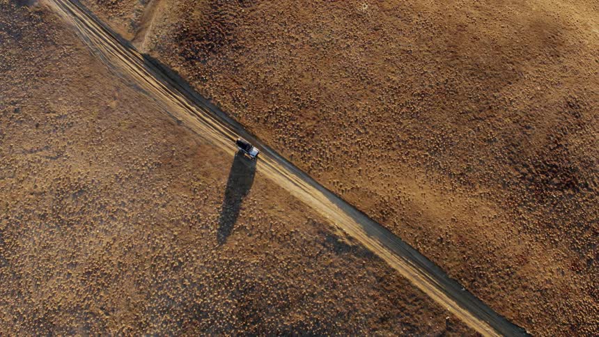 Truck travels on a dirt road in the desert