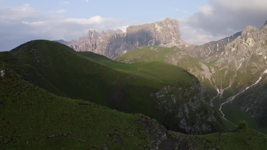Green mountain ridges with spots of snow lining the slopes