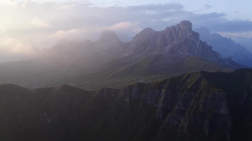 Mist over a mountain range under a cloudy blue sky
