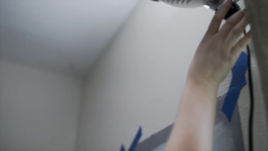 A woman turns on a light in her studio