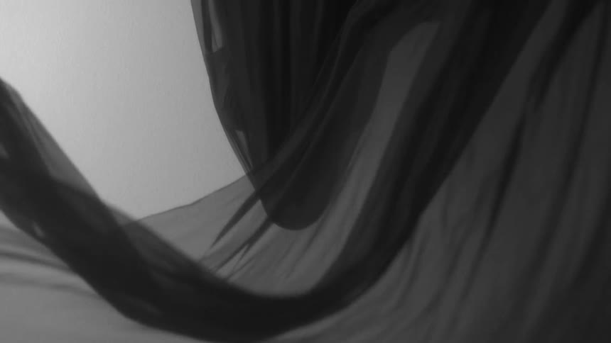 A gray sheet billows in the wind