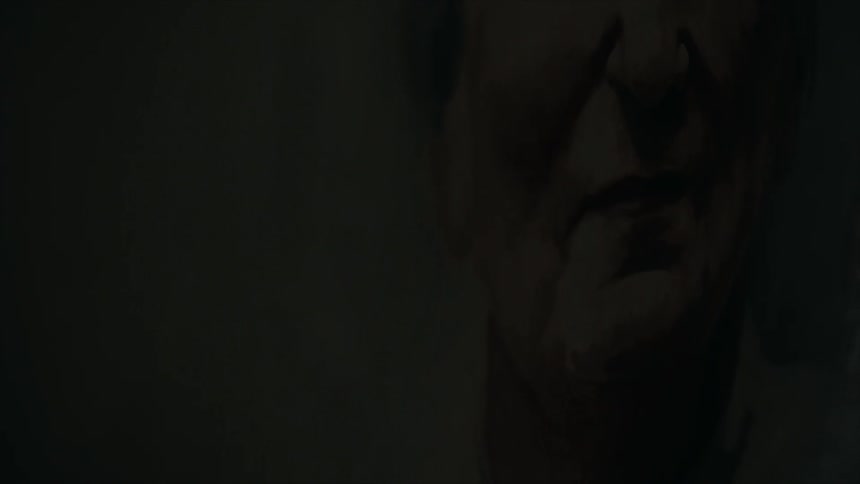 A light turns on to reveal part of an elderly woman's face in a painting