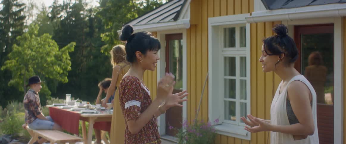 Two women talking to each other outdoors at a party
