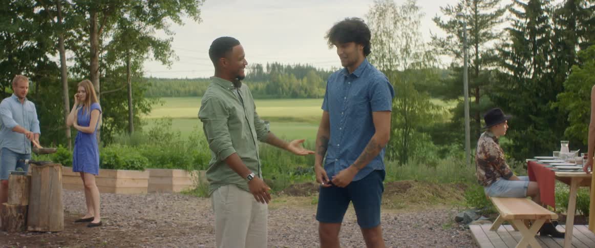 Two men talking to each other and hugging at a party