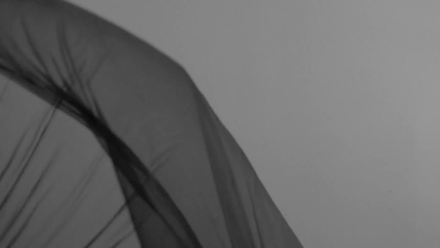 A white and a gray sheet billows in the wind