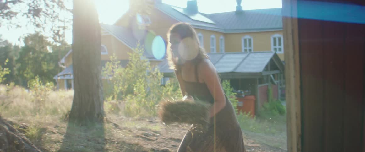 A woman transporting a chunk of hay