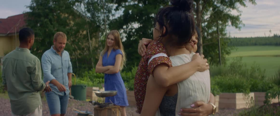 Friends hugging and talking in an outdoors party on the countryside