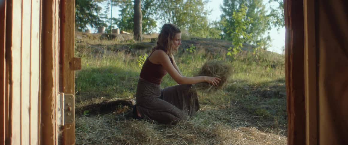 A woman putting leaves and sticks on the ground