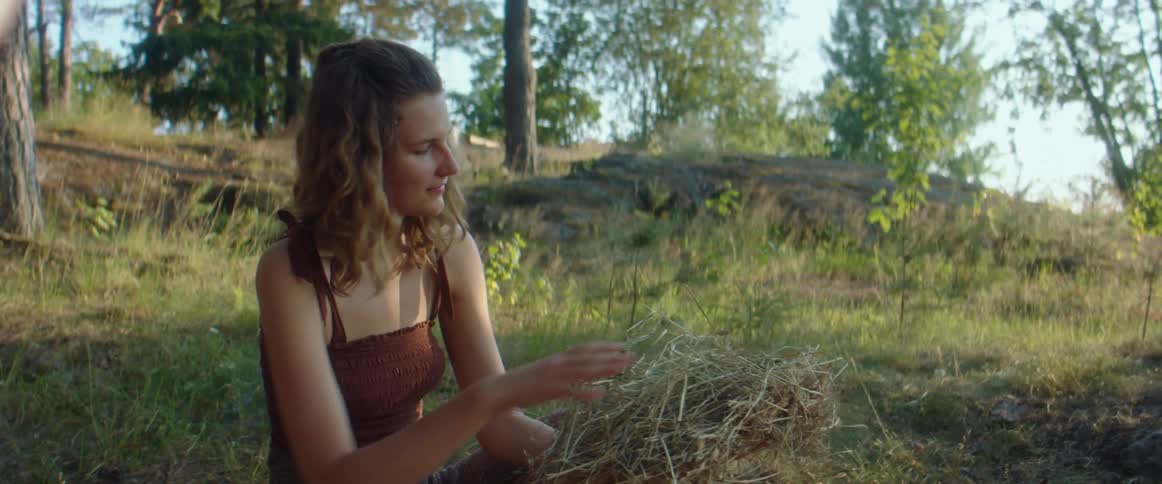 A view of a woman messing with leaves outdoors