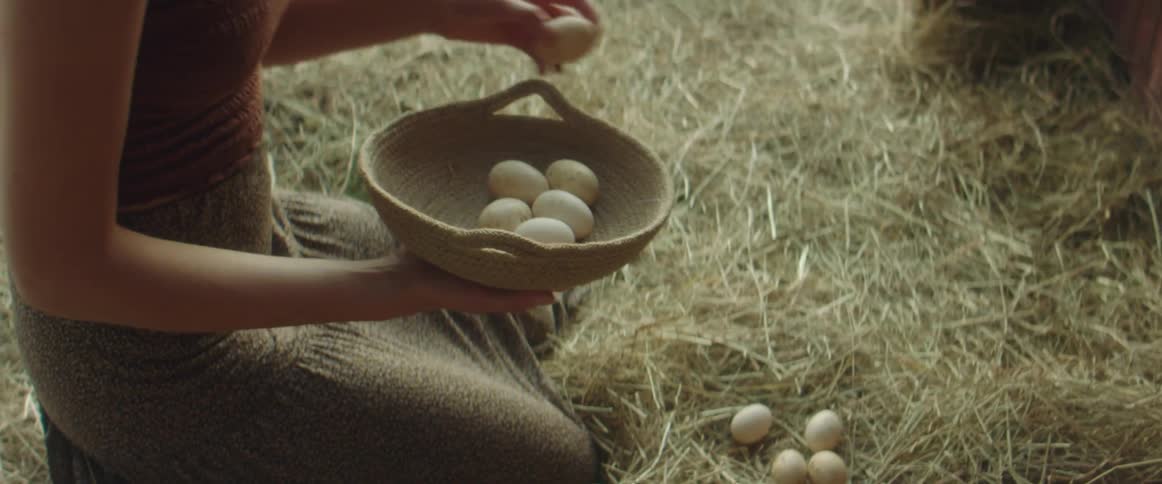A woman picking up eggs