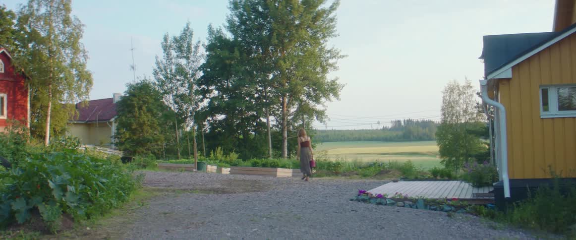 A woman walking out of a house into a yard
