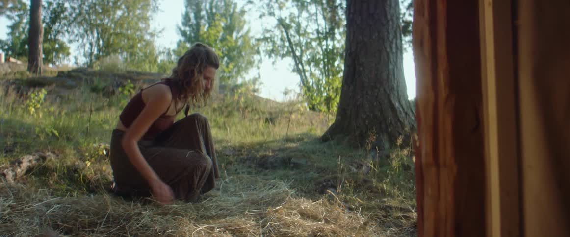 A woman spreading out hay on a farm