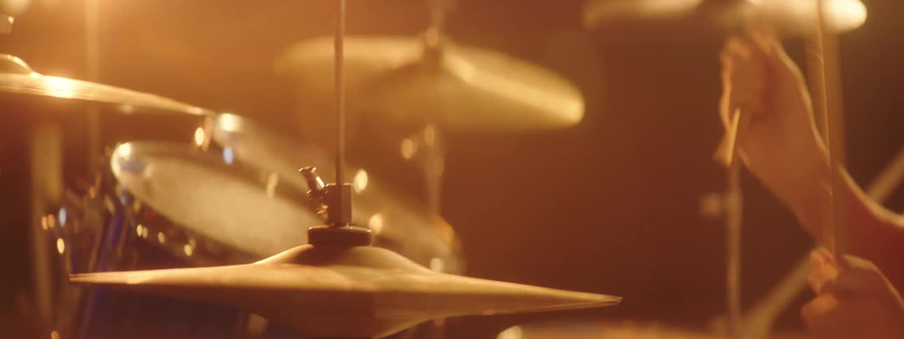 A teenage man playing the drum set