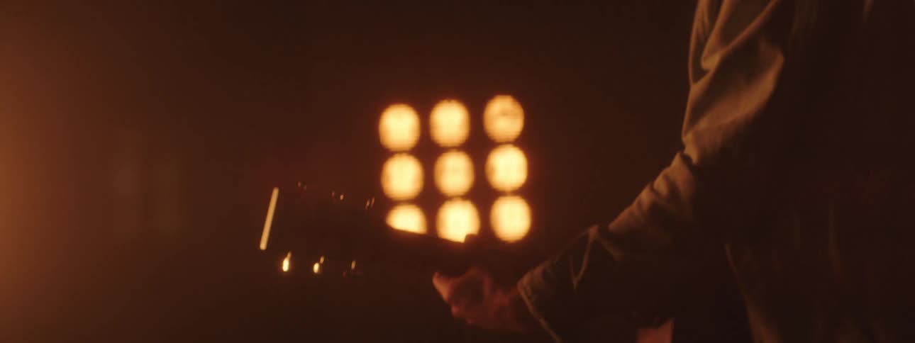 Bright lights shine on a guitarist playing a guitar