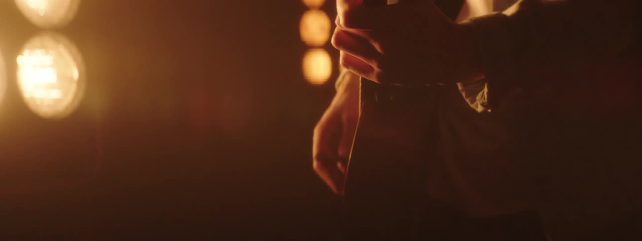 Man plays a guitar as bright lights shine on him