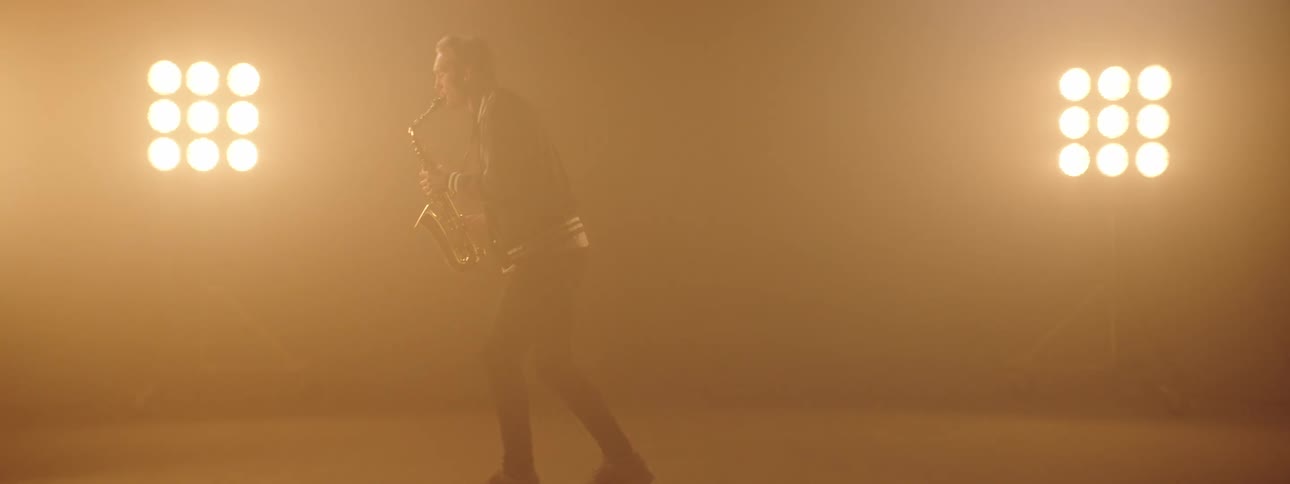 Man plays saxophone in the spotlights on the stage
