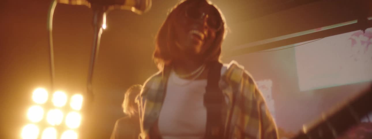 A woman playing a guitar in a band