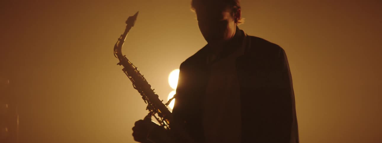 A man with a saxophone walking onto a stage