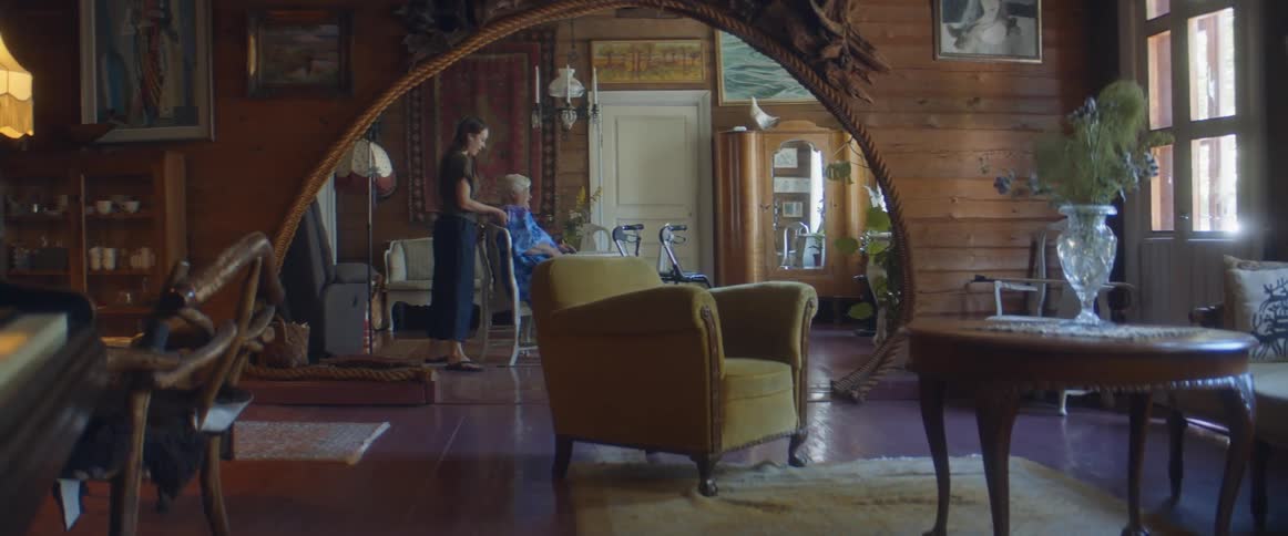 An elderly woman being moved to a different place in the house