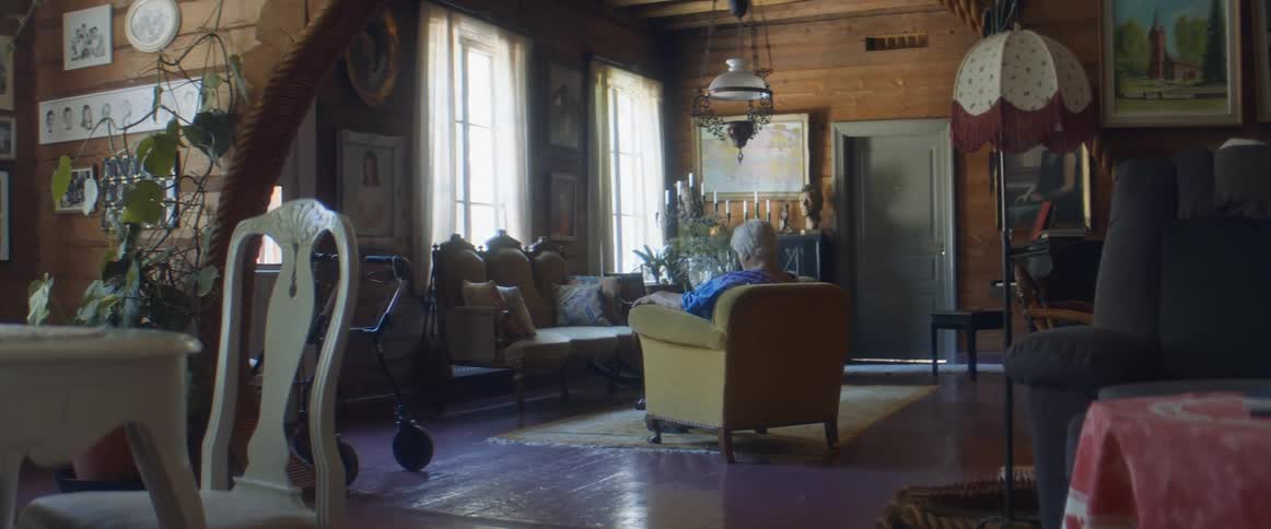 A woman is sitting in a chair in the living room