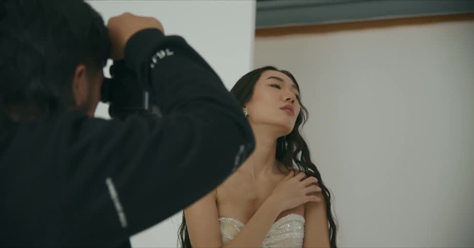 Woman with long black hair poses for a photographer